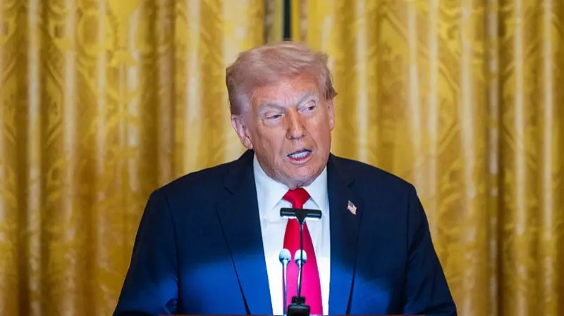 president donald trump wearing nevy blue suit, red tie addressing the people